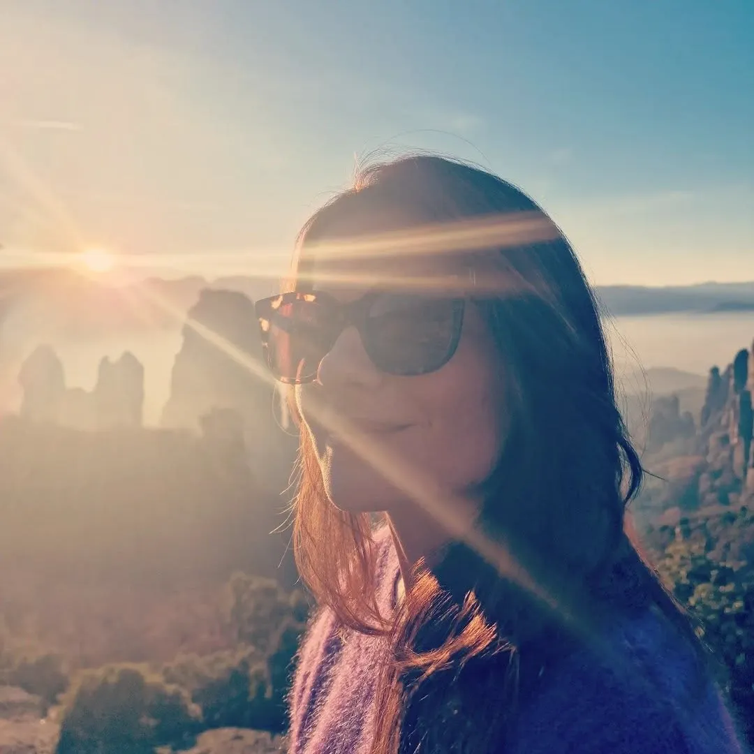 Christina bei Sonnenaufgang über nebelverhangenen Felsnadeln
