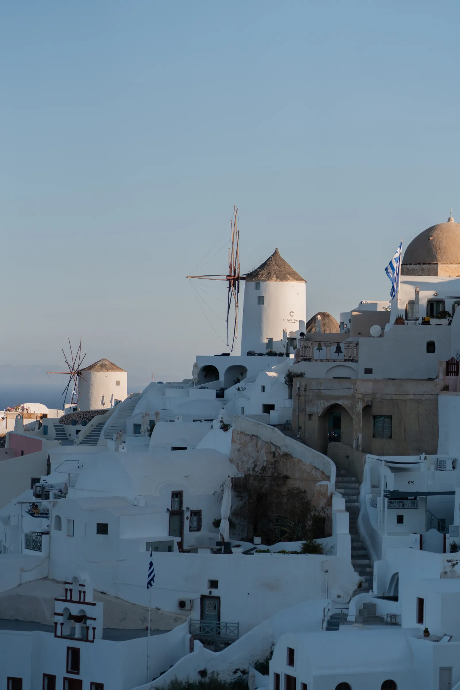 Weiße Häuser und Windmühlen von Oia bei Sonnenuntergang