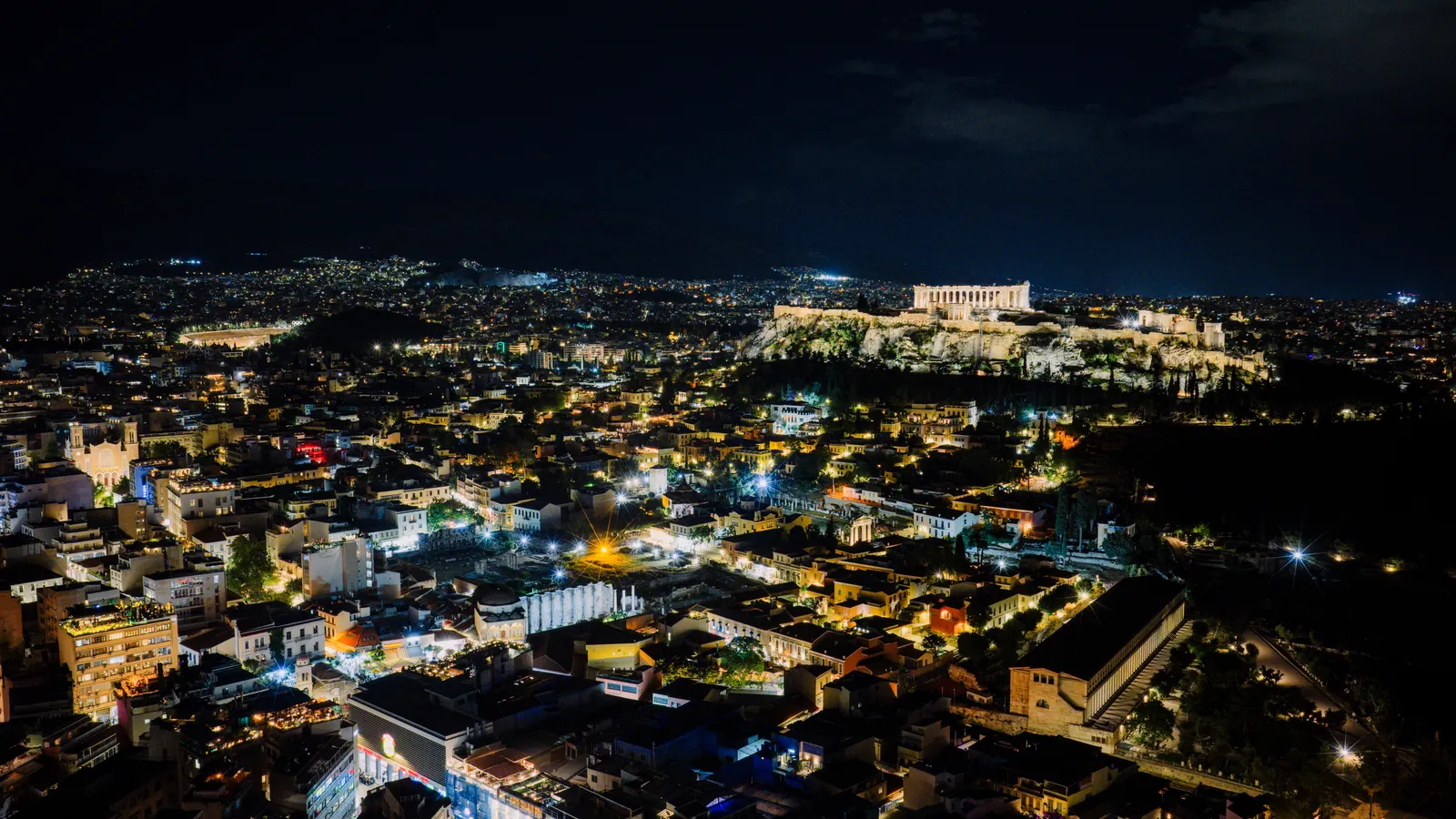 Athen bei Nacht mit beleuchteter Akropolis über der Stadt